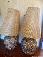 Two matching lamps side by side on wooden surface