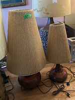 Two lamps side by side on wood floor showing overall size difference and styling