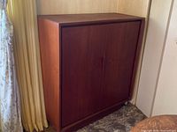 Front view of closed teak cabinet showing overall design and finish