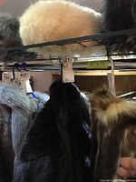 Top shelf view showing white fur hat among other furs