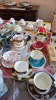 Overview of assorted teacups and saucers arranged on table