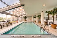 Indoor pool area with shallow end marked and seating.