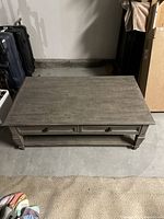 Top view of rectangular gray wood coffee table showing wood grain finish and two drawers.