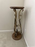 Side angle view showing the wood top and curved metal supports with leaf accents.