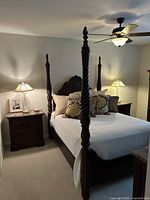 Full view of the Thomasville four-poster bed in a bedroom setting, showing its dark finish and the overall design including headboard and posts.