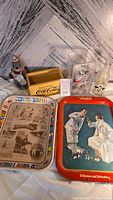 Photo showing entire Coca-Cola lot with two metal trays, wooden crate, two polar bear figurines, and glass bottle