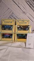 Front view of all four boxed die cast metal classic cars stacked in two rows showing the cars in original packaging.