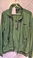 Full front view of green Bench jacket with tags hanging, showing zipper and pockets.