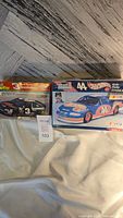 Two boxes side by side: left is the opened Dale Earnhardt SnapTite NASCAR model kit box showing the Goodwrench No. 3 car, right is the sealed Kyle Petty Hot Wheels No. 44 model kit box.