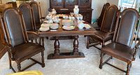 Six dining chairs positioned around a wooden dining table displaying the overall set size and style.