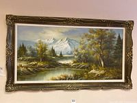 Full view of large framed print showing a panoramic mountain, trees, and water landscape with a detailed and ornate gold-tone frame.