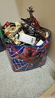Large bag with Spider-Man print containing assorted LEGO pieces, visible castle-themed parts, dragon build parts, and various colors.