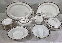 Full view of multiple china items including platters, coffee pot, covered serving dish, bread plates, round serving bowls, teapots, and coffee cups in the South Pacific pattern by Aynsley.