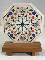Full view of octagonal marble coffee table top insert on wooden stand showing intricate abalone shell and colored stone floral inlay design.