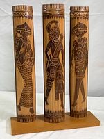 Full view of three carved bamboo figures on wood base showing overall height and width