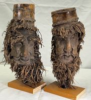 Pair of vintage Chinese bamboo root carvings showing two distinct male faces with natural bamboo root hair and beards mounted on wooden bases.