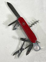 Full view of the vintage Swiss Army pocket tool with all tools extended, showing knife blade, scissors, corkscrew, bottle opener, and other implements.