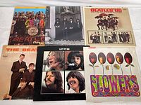 Six vinyl LP album covers arranged in two rows showing artwork for Sgt. Pepper's Lonely Hearts Club Band, Hey Jude, Beatles '65, Introducing...The Beatles, Let It Be, Flowers