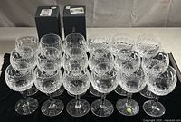 Twenty lead crystal wine glasses arranged in rows with two original Waterford boxes at back
