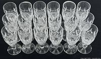 Set of 18 short-stem Waterford Colleen crystal wine glasses arranged in rows, showing uniform size and design.