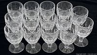 All 16 glasses arranged in four rows on black cloth