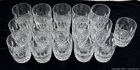 Sixteen Waterford Colleen crystal Old Fashioned glasses arranged on black background