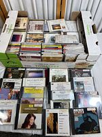 Top view of the large box filled with over 40 classical CDs in cases, organized in rows.