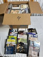 Open box showing multiple Classical CDs stacked and spread out front with visible jewel cases and cover art.