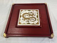 Full view of the wooden serving board with central tile decoration.