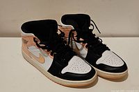 Pair of Air Jordan 1 Mid sneakers size 9 with black, white and peach color scheme, showing front and side angles.