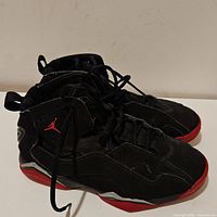 Side angled view of the pair of black and red Air Jordan True Flight sneakers showing shape and condition.