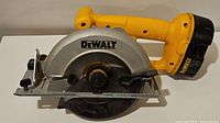 Side view of DeWalt DW939 cordless circular saw showing yellow handle, metal blade guard, and blade.