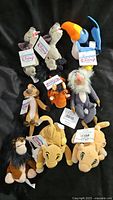 Full lot of nine Disney The Lion King bean bag plush characters shown on black background, including Simba, Nala, Timon, Pumbaa, Scar, Rafiki, Zazu, and two hyenas, all with tags.