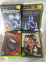 Four original Xbox game cases shown: Psi-Ops the Mindgate Conspiracy, The Chronicles of Riddick Escape from Butcher Bay, Spider-Man, and Soul Calibur II