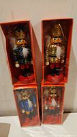 Four nutcracker ornaments in clear red-backed boxes, each about 5 inches tall, featuring different colored sequined jackets and crowns.