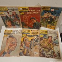Photo of 7 Classics Illustrated comic books showing classic literature titles with illustrated covers and visible wear.