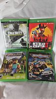 Photo showing front covers of Call of Duty: Infinite Warfare Legacy Edition, Red Dead Redemption 2, Minecraft, and Micro Machines World Series Xbox One game cases.