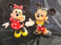 Front view of colorful Mickey Mouse and Minnie Mouse ceramic figurines, showing detailed paint and glossy finish.