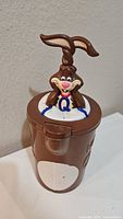 Front view of brown plastic Nestle Quick pitcher with bunny figurine lid, showing clean condition and embossed logo.