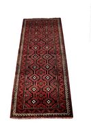 Full view of the rectangular Persian Baluchi rug with complex geometric patterns in red, black, and cream colors.
