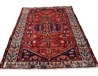 View of entire Persian Zanjan rug showing red field with central hexagonal medallions and white edge border with floral and geometric patterns.