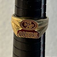 Front view of gold ring showing red enamel “SF” logo and “49ERS” text