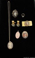 Top view of the cameo jewelry laid out on a black background, showing all items front facing