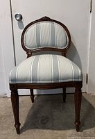 Front view of the French Provincial style chair showing the curved wooden frame and striped upholstery.