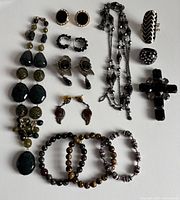 Full lot image showing all jewelry pieces: necklaces, bracelets, earrings, rings, cross pendant