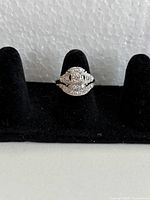 Front view of engagement ring stacked with matching band on black display stand