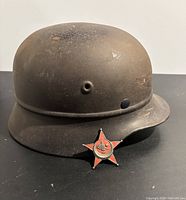 Side view of worn WWII Turkish helmet with Gallipoli star pin placed at the front brim.