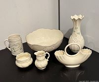 Photo showing all six pieces: a basketweave mug, large bowl, creamer, sugar bowl, Belleek Rock of Cashel vase, and Lenox double Wedding Ring vase
