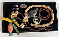 Full view of wooden carved fruit pieces, jewelry items including bangles, necklaces, pendants, and earrings on black tray showing lot contents