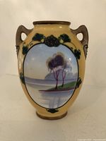 Front view of Noritake Maruki miniature vase with scenic hand-painted landscape and yellow floral background.